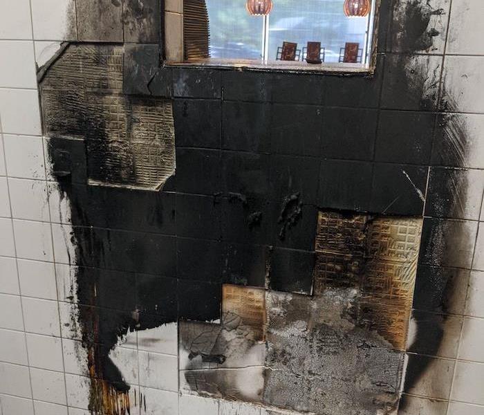 Commercial fire damage on restaurant kitchen tile wall 