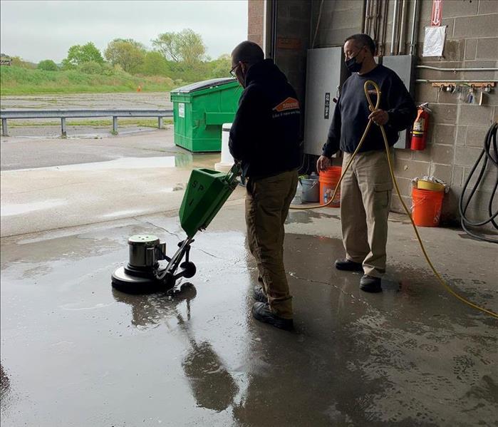SERVPRO techs with a polisher on a concrete floor